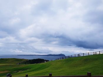 Scenic view of grassy field against sky