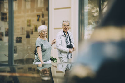 Smiling senior couple walking exploring in city during vacation