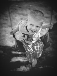 Portrait of smiling boy playing on swing