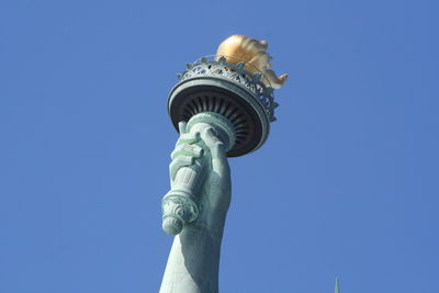 Torch of liberty against clear sky on sunny day