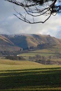 Scenic view of field and mountains against sky