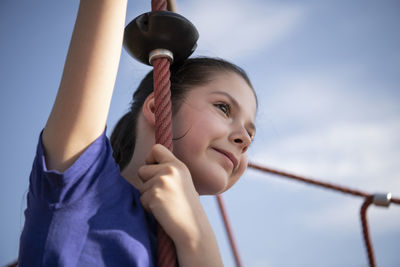 Low angle portrait of smiling girl against sky