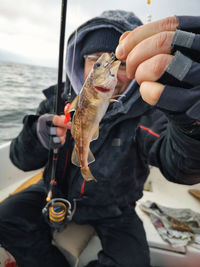 Cropped hand holding fish