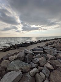 Rocks by sea against sky