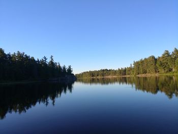 Scenic view of lake against clear blue sky
