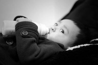 Close-up portrait of cute baby relaxing on bed at home