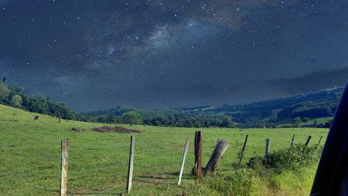 Scenic view of landscape against star field at night