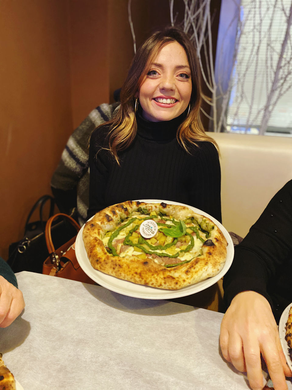 real people, one person, food and drink, lifestyles, smiling, food, indoors, women, leisure activity, holding, plate, freshness, business, young women, restaurant, front view, young adult, sitting, ready-to-eat, hand, hairstyle