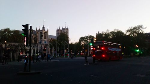 Cars on road in city against clear sky