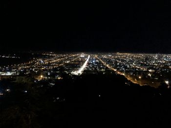 High angle view of illuminated city against sky at night