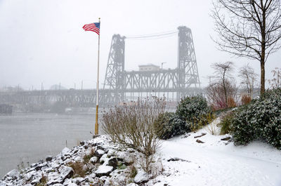 American flag blowing with wind by willamette river at park