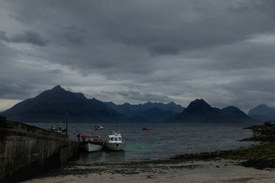 Scenic view of sea and mountains against sky