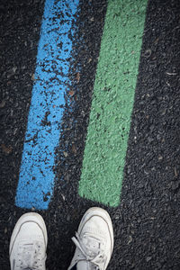 Low section of person standing on road