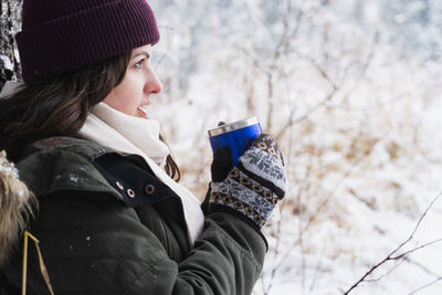 Young woman drinking glasses on snow