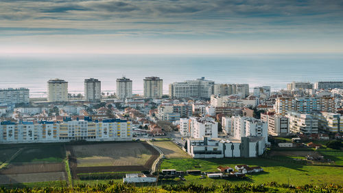 High angle view of buildings by sea against sky