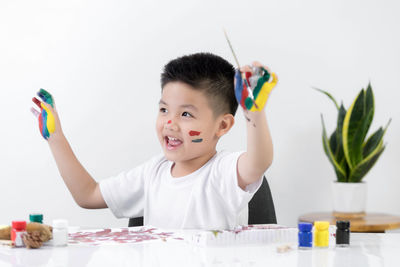 Portrait of smiling boy holding table