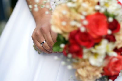 Close-up of hand holding red rose