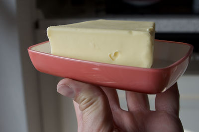 Close-up of hand holding butter with heart 
