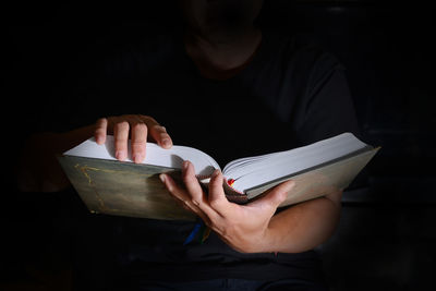 Midsection of man holding book