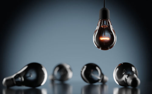 Close-up of light bulb hanging against wall