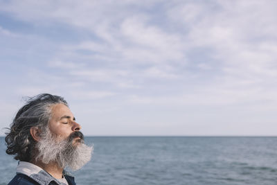 Close up side view of a bearded man breathing fresh air with copy space