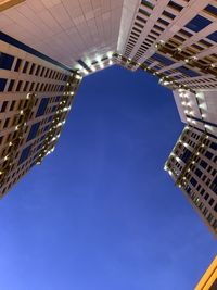 Low angle view of buildings against clear blue sky