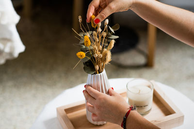 Midsection of woman holding flower arrangement 