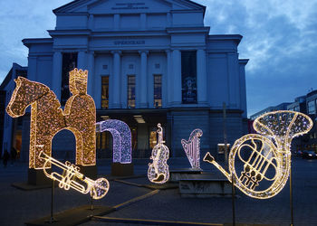 Low angle view of illuminated building against sky in city