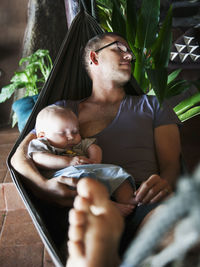 Father with baby seeping on hammock, thailand