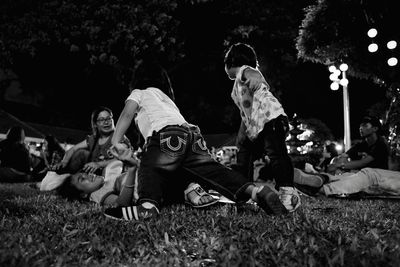 Playful family on field at park during night