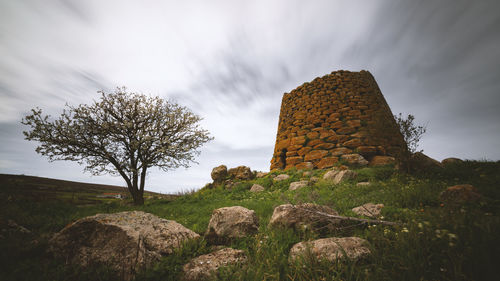 Low angle view of rocks on field against sky