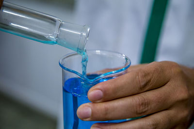 Midsection of male scientist experimenting in laboratory