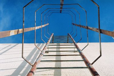 Low angle view of ladder against blue sky