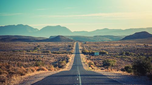 Empty road leading towards mountains