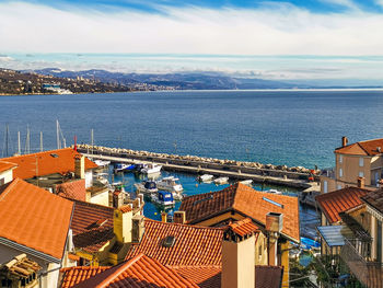 High angle view of buildings by sea against sky volosko/opatija 