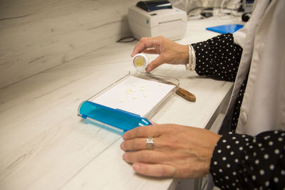 High angle view of woman hand on table