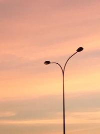 Low angle view of illuminated light against orange sky