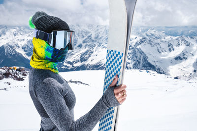 Portrait of a slender muslim sportswoman skier with a closed face with skis in her hands against 