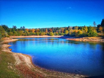 Scenic view of lake against clear blue sky