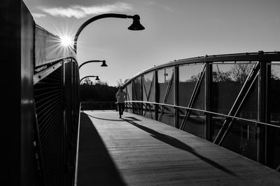 Man on bridge in city against sky