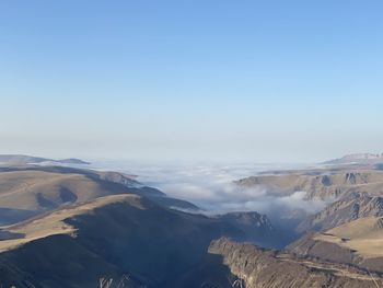 Aerial view of snowcapped mountains against blue sky