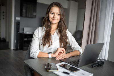 Young woman using laptop at table