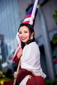 Portrait of smiling young woman standing in car