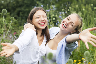 Portrait of smiling young woman against plants