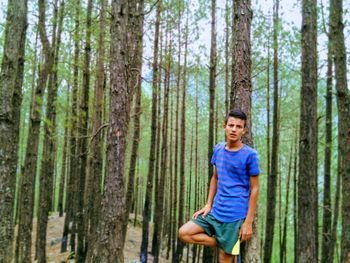 Full length of a smiling young man in forest