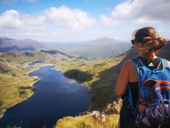 Woman standing on mountain against sky