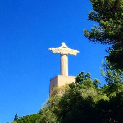 Low angle view of statue against blue sky