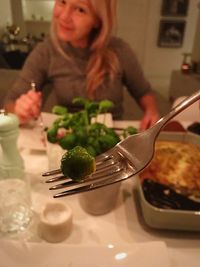 Midsection of woman having food in restaurant