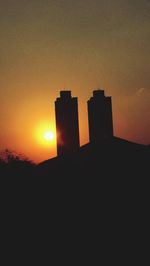 Silhouette buildings against sky during sunset