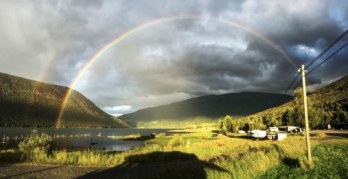 Scenic view of rainbow over mountain against sky